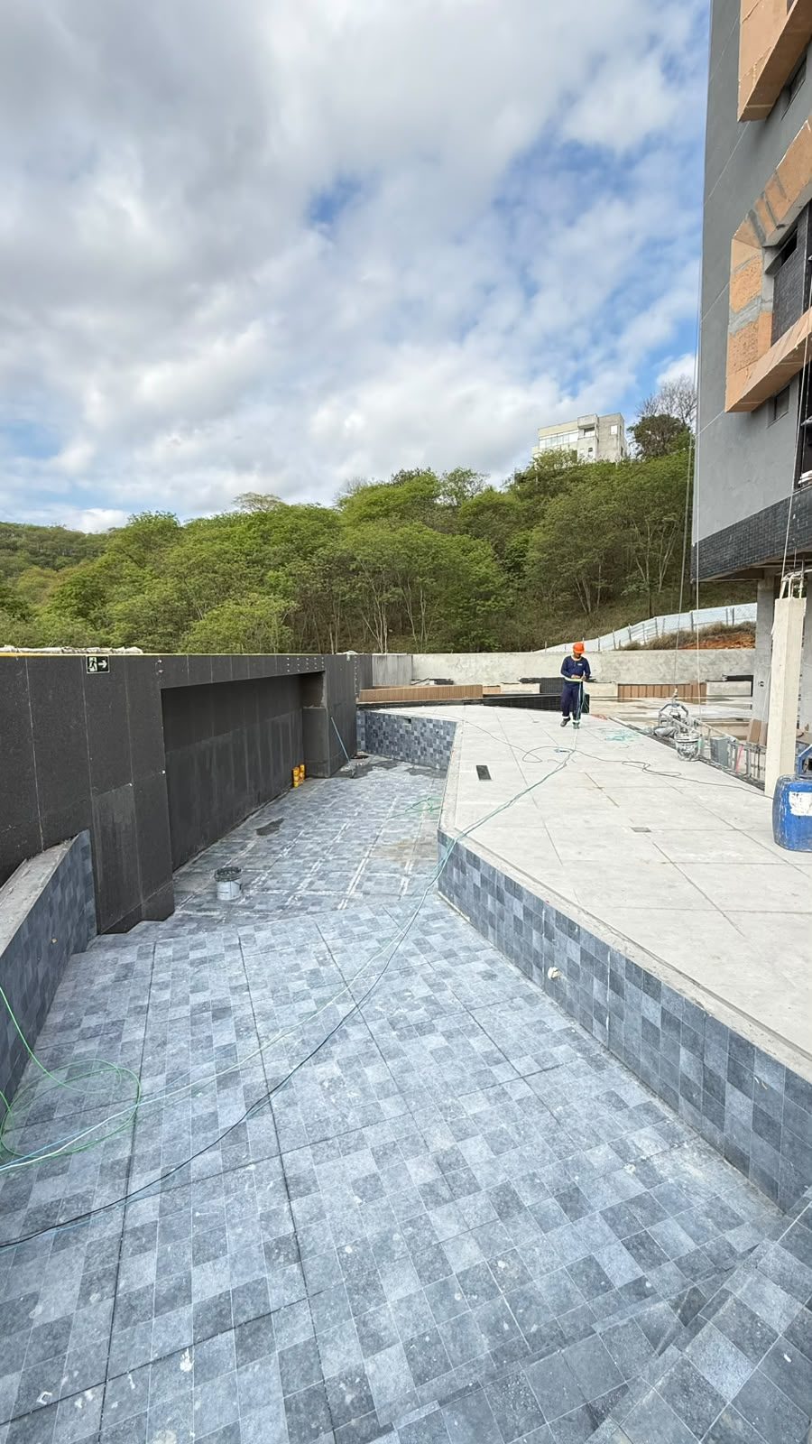 Piscina da área de lazer do Van Gogh Residencial com o revestimento em pastilha cinza aplicado e o deck ao lado