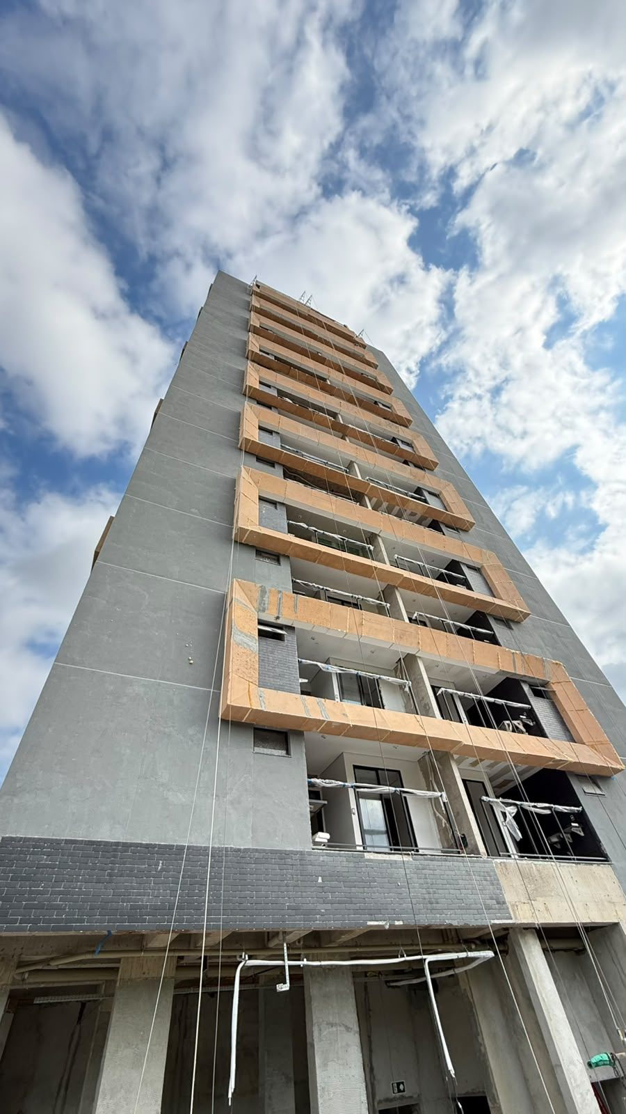Fachada do Van Gogh Residencial vista de baixo, com as molduras das sacadas instaladas e esquadrias de vidro já colocadas